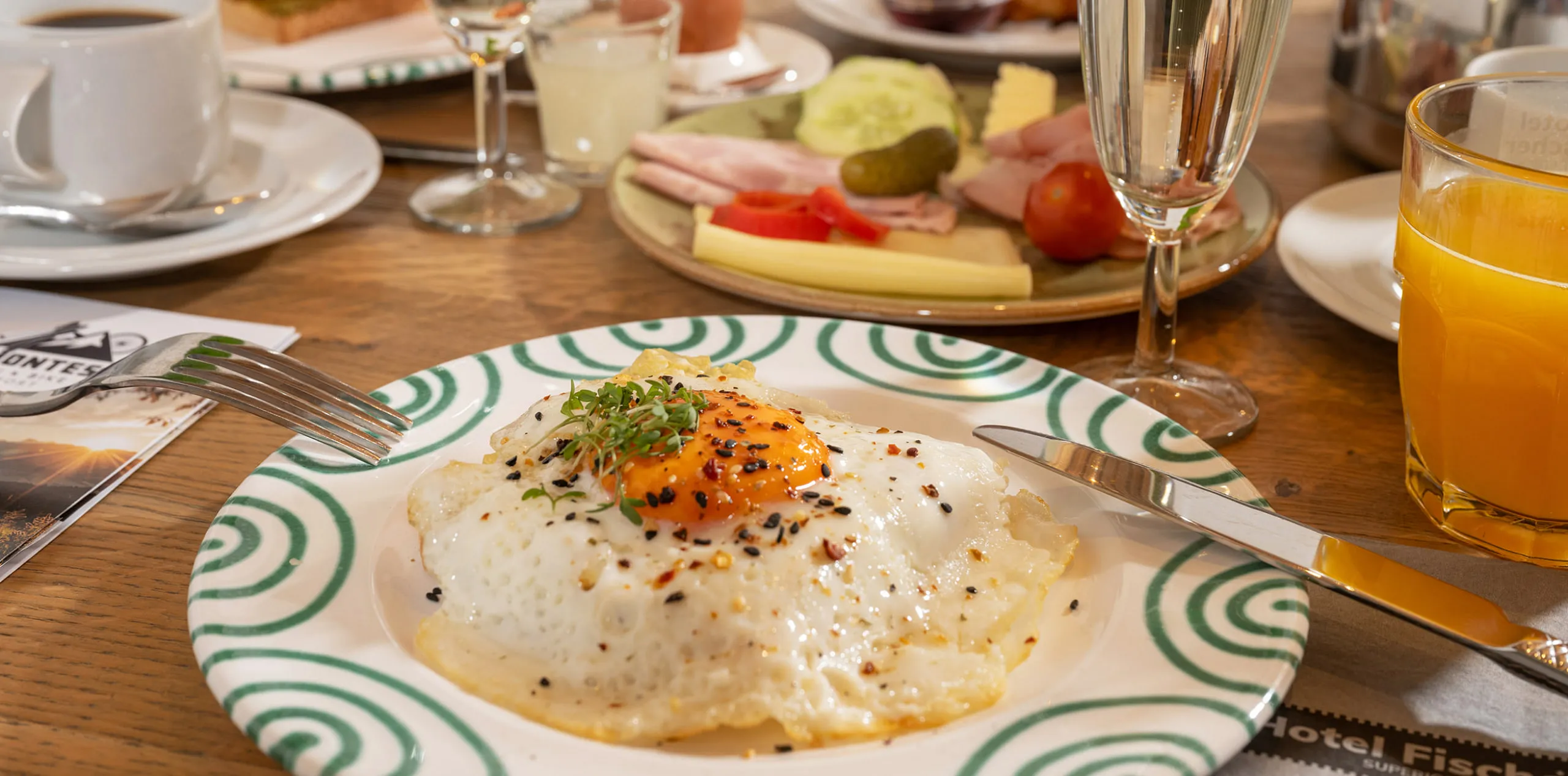 Frühstücksteller mit Spiegelei und anderem Frühstücksangebot