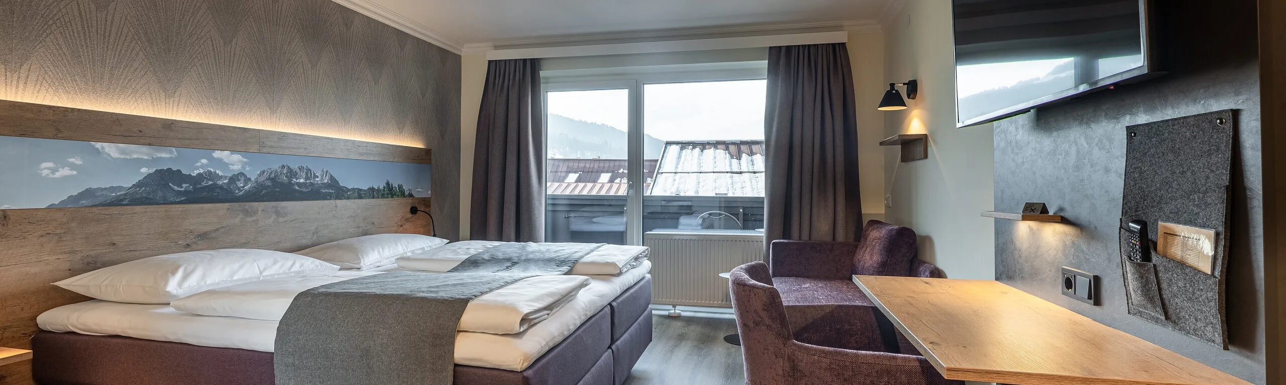Doppelzimmer Kitzbüheler Horn mit Boxspringbett, Bergpanorama und Schreibtisch im Hotel Fischer