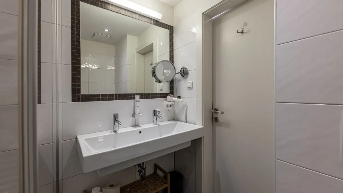 Helles Badezimmer mit Doppelwaschbecken und Spiegel